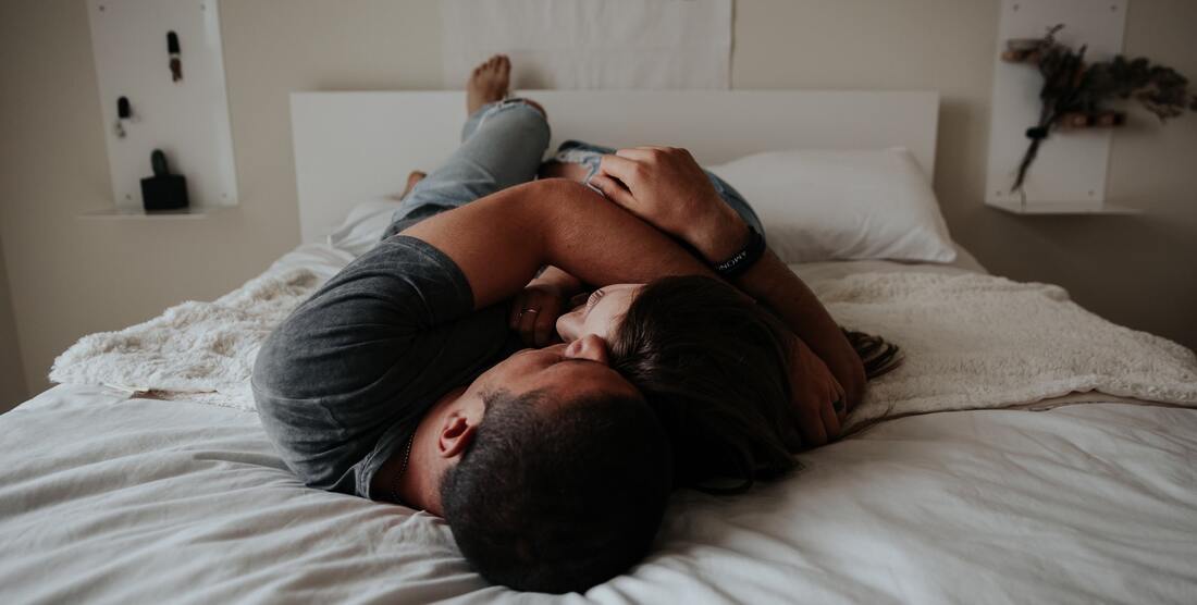 coppia sdraiata sul letto abbracciata